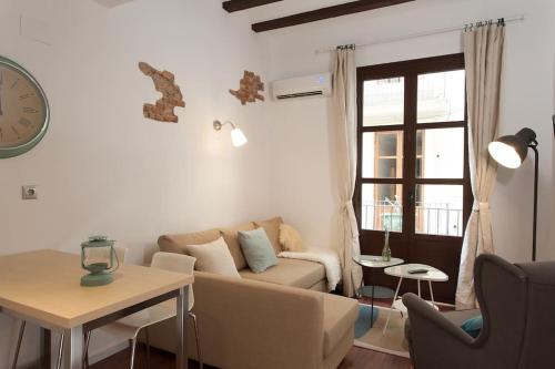 uma sala de estar com um sofá, uma mesa e um relógio em Flat in Bacelona Center em Barcelona