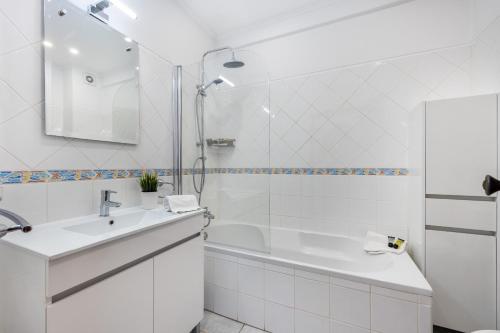 een witte badkamer met een douche en een wastafel bij Apartamento Santa Terezinha by Seewest in Lagos