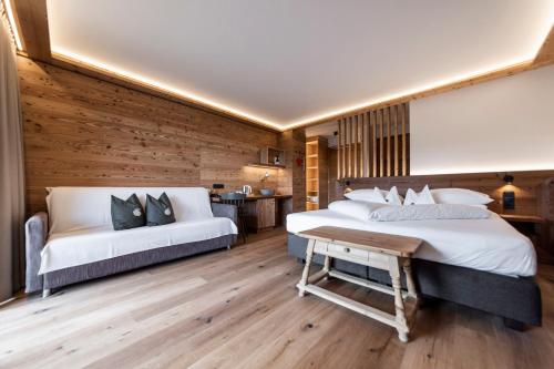 a bedroom with two beds and a table in it at Hotel Tann in Collalbo