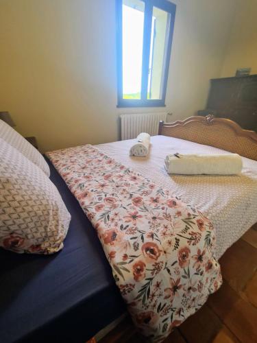 - un lit avec une couverture fleurie et une fenêtre dans l'établissement Grand Gite Avec Tennis et Piscine, à Lalinde