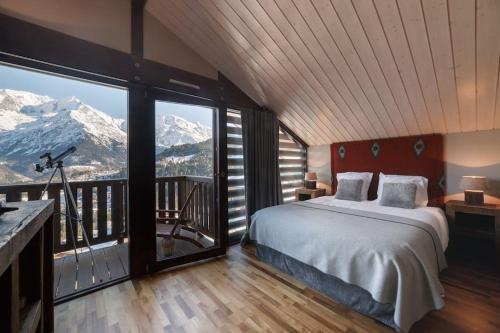 1 dormitorio con 1 cama y ventana grande con vistas a las montañas en L'ivresse du Mont-Blanc, en Saint-Gervais-les-Bains