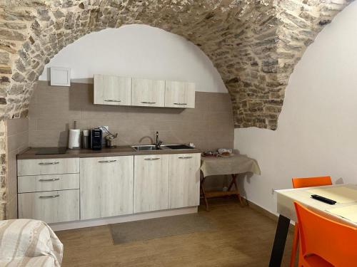 Pietra MontecorvinoにあるLa Tavernettaの石壁のキッチン、シンク付きのカウンター