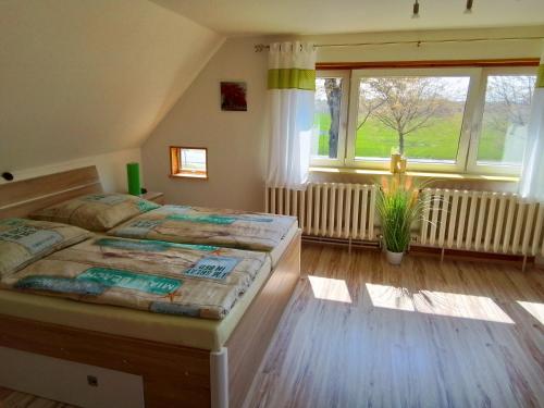 a bedroom with a large bed and a large window at Haus im Wind in Putbus