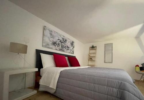 ein Schlafzimmer mit einem großen Bett mit roten Kissen in der Unterkunft Casa Graziella in Brindisi