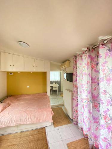a bedroom with a bed and pink curtains in it at Private Apt. Acropolis View. Top Floor. Koukaki in Athens