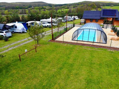 an aerial view of a camping site with a greenhouse and tents at Ubytovanie Koliba Pacho - Zrub Evka in Prievidza