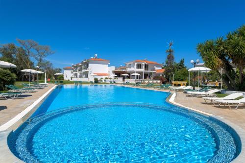 a large swimming pool with blue water in a resort at Eleonas Apartments in Ialysos