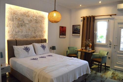 a bedroom with a bed and a table with chairs at Golden Mile STUDIO-APARTMENT in Ipsos