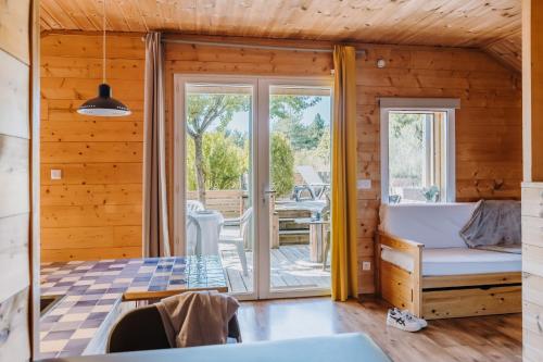 Holzhütte mit einem Wohnzimmer und einer Terrasse in der Unterkunft Sunêlia Camping la Presqu'île in Prunières