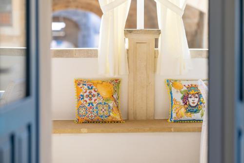 two pillows on a window sill with curtains at Le Antiche Dimore di Cadia in Ugento