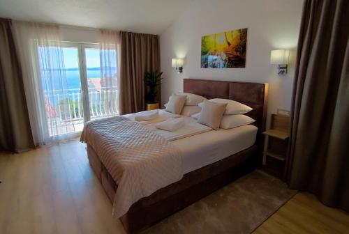 una camera con un grande letto e una grande finestra di Apartments Jakšić a Trogir