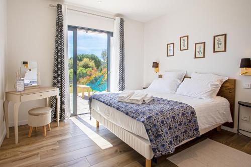 um quarto com uma cama, uma secretária e uma janela em Domaine de l'auberderie Tropezienne em Plan-de-la-Tour
