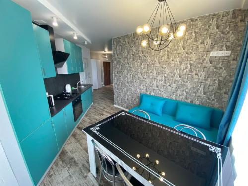 a kitchen with blue cabinets and a blue couch at FlatService Апартаменти в сучасному ЖК Parklend in Kyiv