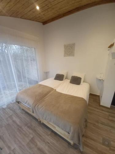 ein Schlafzimmer mit einem großen Bett und einem großen Fenster in der Unterkunft L'ANNEXE in Chaumont