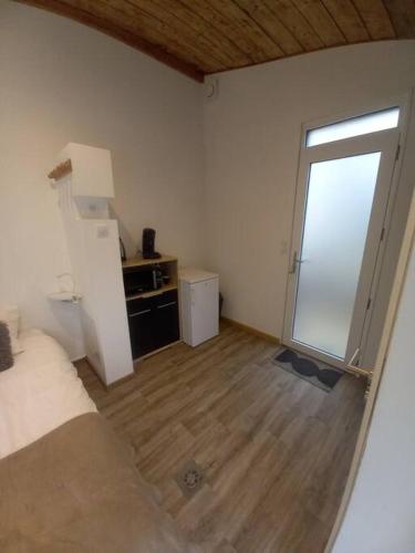 Zimmer mit einem Bett und einer Glasschiebetür in der Unterkunft L'ANNEXE in Chaumont
