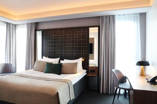 a hotel room with a bed and a desk and a desk at Hotel Reykjavík Saga in Reykjavík
