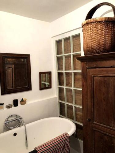 a bathroom with a bath tub and a window at Atypical Town House in Uzès. in Uzès