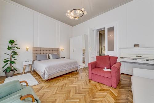 1 dormitorio con 1 cama y 1 silla rosa en Central family apartment en Arad