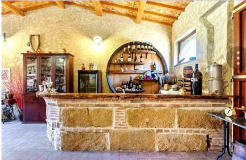 a bar in a room with a stone wall at Sa Pramma in Baratili San Pietro
