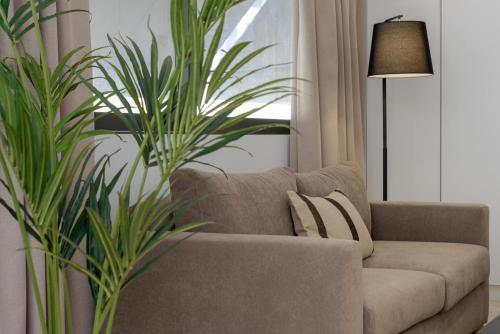 a living room with a couch and a plant at Aura Homes, Contemporary Apartments in Central Athens in Athens