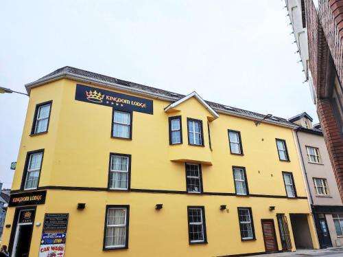 a yellow building with a street sign on it at Kingdom Lodge in Killarney