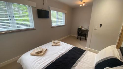 a bedroom with a bed with towels on top of it at Deepcut Lodge Bed & Breakfast Self Service in Camberley