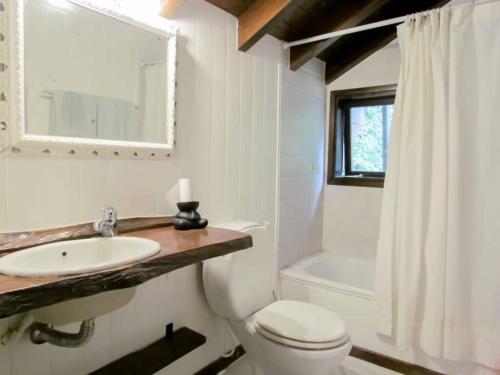 La salle de bains est pourvue d'un lavabo, de toilettes et d'une baignoire. dans l'établissement Villa La Angostura - El Encuentro: Un lugar soñado, à Villa La Angostura
