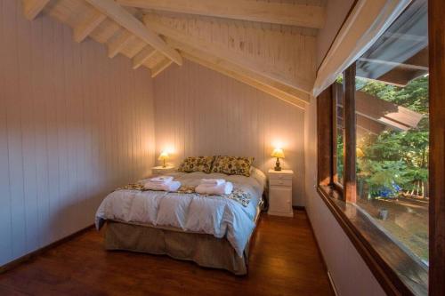 - une chambre avec un lit et une grande fenêtre dans l'établissement Villa La Angostura - El Encuentro: Un lugar soñado, à Villa La Angostura