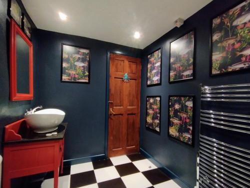 a bathroom with a sink and a blue wall at Trethellan View in Stithians