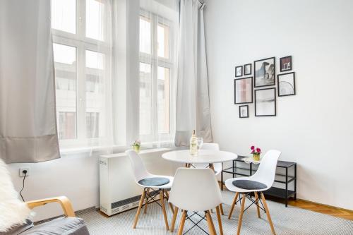 biały salon ze stołem i krzesłami w obiekcie Miodowa Kazimierz Apartment w Krakowie