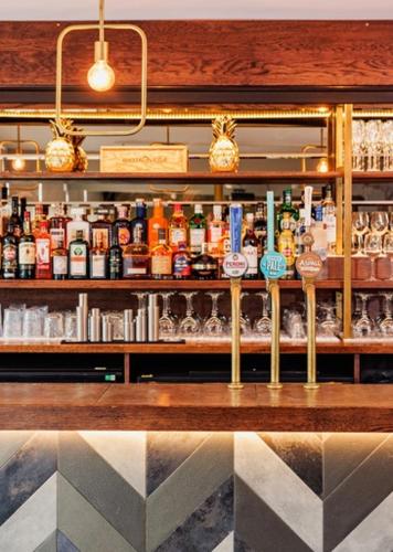 a bar with a lot of bottles of alcohol at The High Field Town House in Birmingham