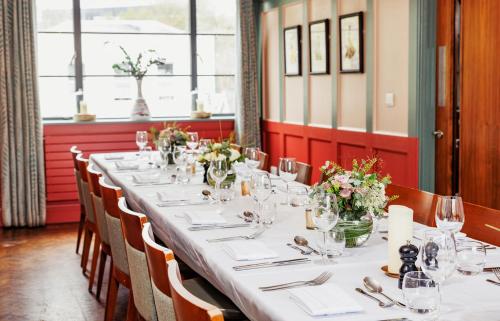 a long table in a restaurant with flowers on it at The High Field Town House in Birmingham