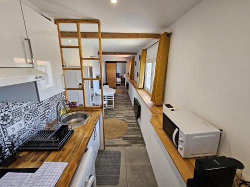 une petite cuisine avec un évier et un micro-ondes dans l'établissement Casita Hendaya - Agréable et cosy avec parking et WiFi, à Hendaye