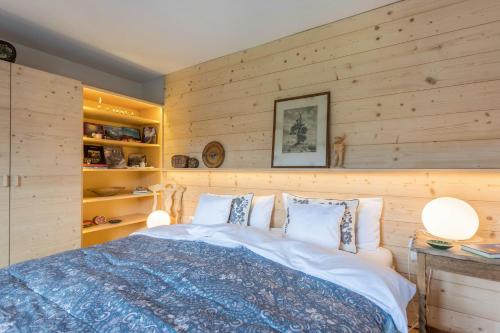 a bedroom with wooden walls and a large bed at Haus Alpenveilchen - Appartement 3 in Schönau am Königssee