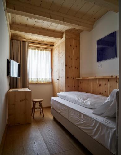 a bedroom with a large bed and a window at Dolomiti Lodge Alverà in Cortina dʼAmpezzo