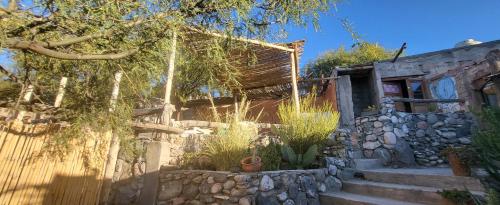 een stenen huis met een stenen muur en een trap bij Pacha Cuty Hostel in Amaichá del Valle