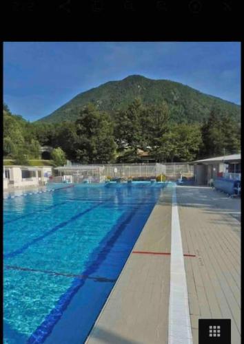 une grande piscine avec une montagne en arrière-plan dans l'établissement Maison Centrale, à Ax-les-Thermes