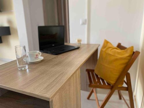 a laptop computer sitting on a wooden table with a chair at Sissi Olive home in Sisi