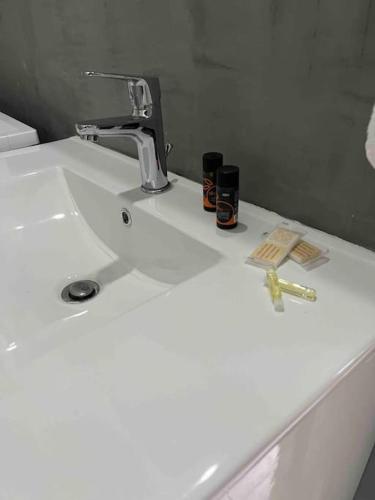 a white bathroom sink with a faucet and two candles at Sissi Olive home in Sissi