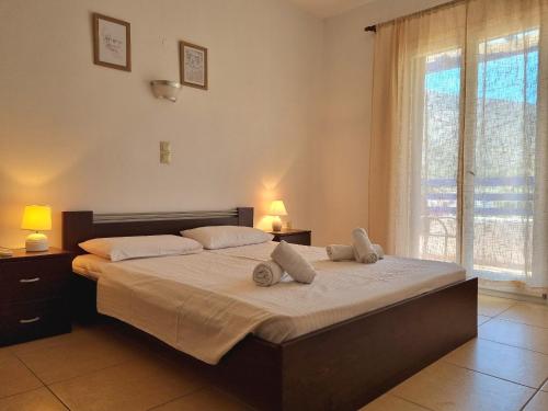 a bedroom with a large bed and a large window at Zafeiris Apartments in Livadia