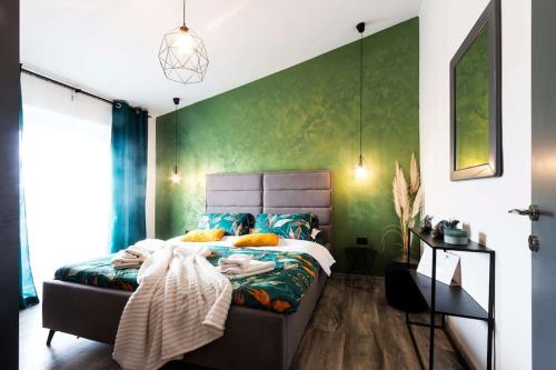 Un dormitorio con una cama y una pared verde. en Apartman Smaragd, en Fažana