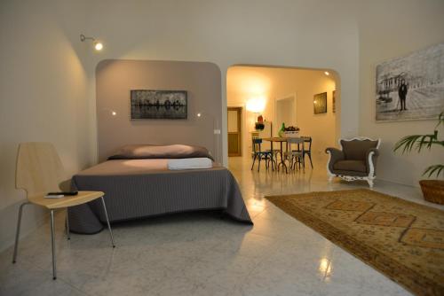 1 dormitorio con 1 cama, mesa y sillas en La Locanda dei Corrieri, en Palermo