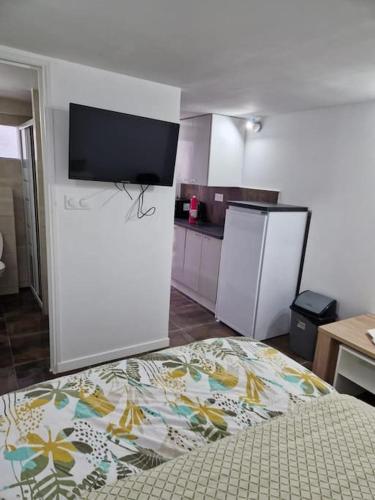 a kitchen with a bed and a tv in a room at Studio 2 pers Paris/Bourget/CDG/Parc d'Exposition in Aulnay-sous-Bois