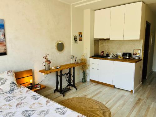 een keuken met een bed en een tafel in een kamer bij Relax studio in Sozopol