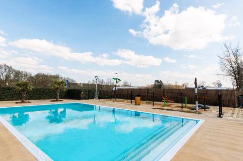 duży basen z niebieską wodą w obiekcie Vakantiepark Vinkenhof w mieście Schin op Geul