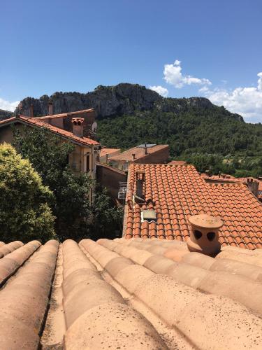 a view of the roofs of a town with a mountain at La Parenthèse in Tautavel