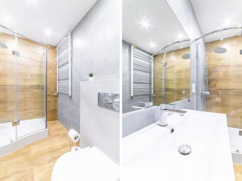 W łazience znajduje się prysznic i biała umywalka. w obiekcie Piękny dom blisko lasu i Krakow Airport w Zabierzowie