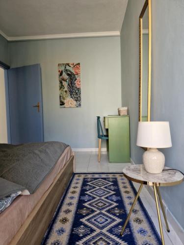 um quarto com uma cama e uma mesa com um candeeiro em Kanari em Cidade de Kos