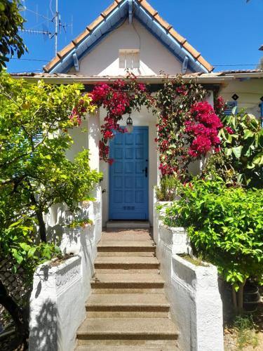 a white house with a blue door with flowers at Au fil de l eau in Cannes