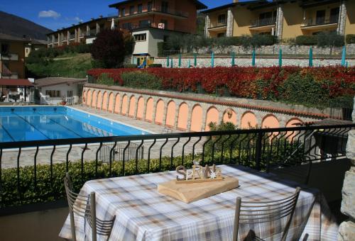 - une table sur un balcon à côté de la piscine dans l'établissement Appartamento Anna 701 - Gardagate, à Tignale